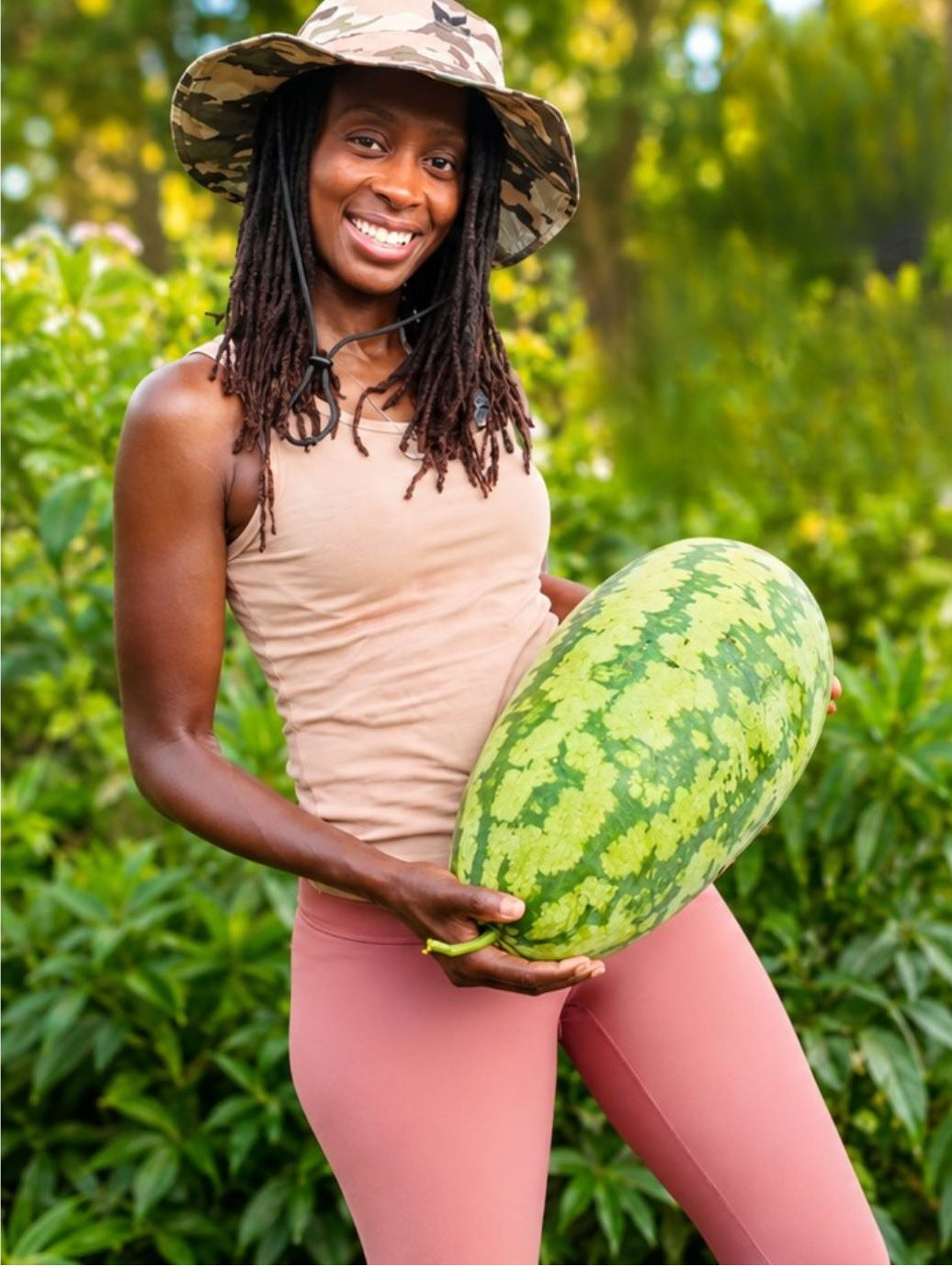 Toni in the garden holding a watermelon she grew