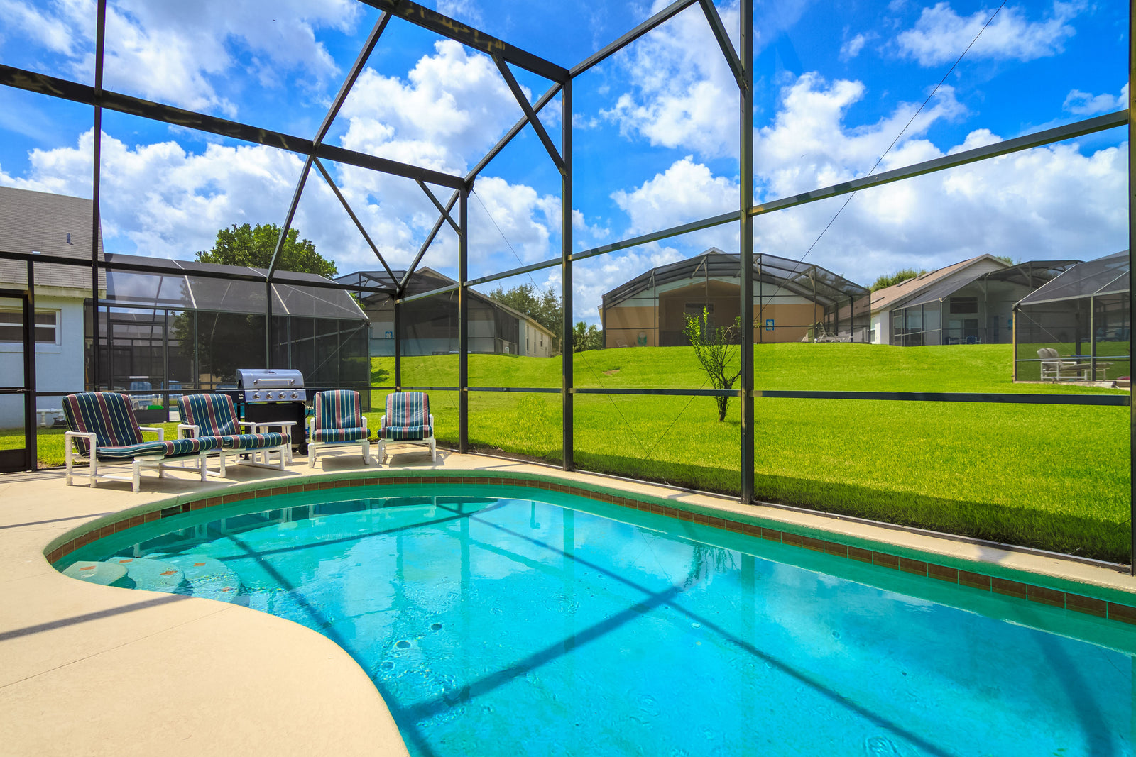 A screened pool enclosure behind a Florida home