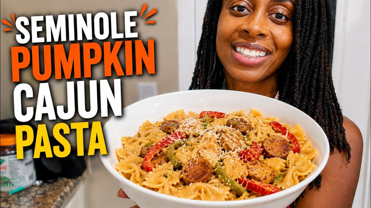Creamy Seminole pumpkin Cajun shrimp pasta in a skillet with peppers, sausage and shrimp on top
